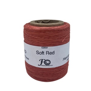 May include: A spool of soft red waxed thread for hand sewing. The spool is labelled "Soft Red" and has the logo "FO, Fused Thread Designs".