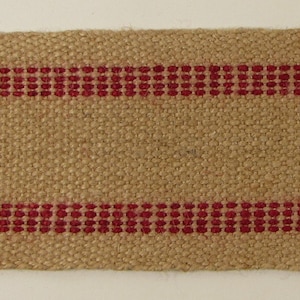 Peut inclure: Gros plan sur un ruban de toile de jute naturel avec deux bandes rouges. Les bandes sont tissées avec de petits points rouges.