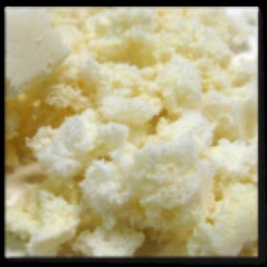 May include: Close-up of a pile of white and yellow shredded coconut.