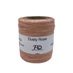 May include: A spool of dusty rose waxed linen thread. The label reads "Dusty Rose" and "Foxcraft Threads".