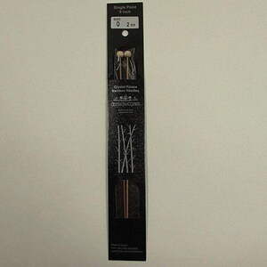 May include: A pair of 9-inch single point bamboo knitting needles in size 0 (2 mm) from Crystal Palace. The needles are packaged in a black and white cardboard sleeve with a bamboo design.