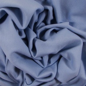May include: A close-up of a soft, blue fabric. The fabric is wrinkled and folded, showing its texture.