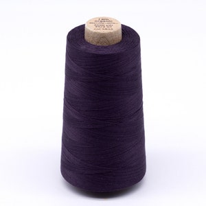 Könnte beinhalten: Eine Spule mit dunkelviolettem Garn, beschriftet mit "I am organic" und "3000 yds 30/2 wt col 4845".