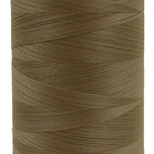 Puede incluir: Una bobina de hilo beige.