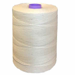 May include: A spool of natural white cotton thread with a purple plastic top.