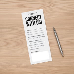 Könnte beinhalten: Ein weißes Formular mit dem Text "CONNECT WITH US!" und Feldern für Name, Telefon und E-Mail. Es enthält Kontrollkästchen für bevorzugte Kommunikationsmethoden und Interessengebiete. Ein silberner Stift liegt auf einer Holzoberfläche.