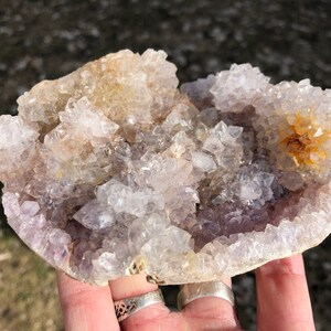 K&ouml;nnte beinhalten: Ein Cluster aus Amethyst-Kristallen mit einem hellvioletten Farbton und klaren Quarzkristallen. Die Kristalle sind in einer nat&uuml;rlichen Formation angeordnet und bilden ein einzigartiges und wundersch&ouml;nes Display.