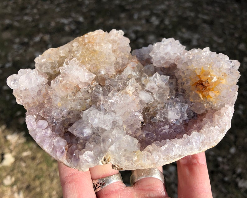 K&ouml;nnte beinhalten: Ein Cluster aus Amethyst-Kristallen mit einem hellvioletten Farbton und klaren Quarzkristallen. Die Kristalle sind in einer nat&uuml;rlichen Formation angeordnet und bilden ein einzigartiges und wundersch&ouml;nes Display.