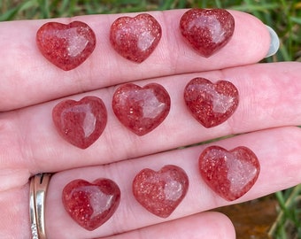 May include: Eight heart-shaped red gemstone crystals with a sparkly, translucent finish.