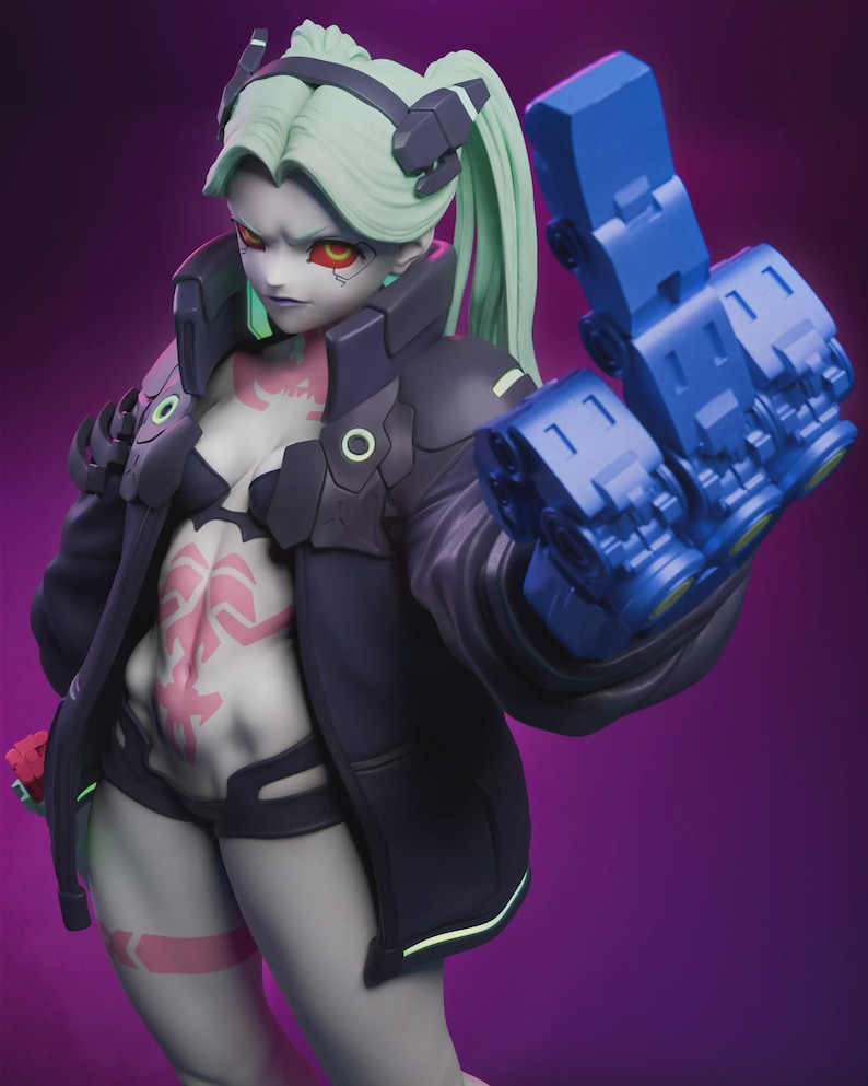 May include: A detailed figurine of a female character with pale skin, green hair in a ponytail, and red eyes. She wears a black jacket, shorts, and a blue mechanical arm. Pink tattoos adorn her torso and legs. The background is a gradient of purple.