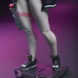 May include: A futuristic figurine featuring a character with pale skin, wearing black shorts, a jacket, and high-top sneakers. The figure stands on a geometric platform, holding a futuristic weapon. A pink band with a white "K" is on the thigh.