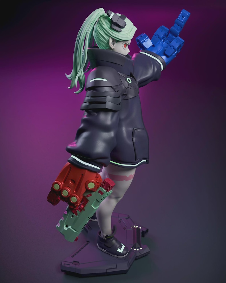 May include: A figurine of a character with green hair, red eyes, and a black outfit with white accents. The figure is holding a blue hand up and a red and green weapon. The figure is standing on a black base with a purple background.