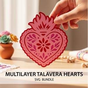 May include: A layered, pink Talavera heart design with intricate floral and dot patterns. The heart is held by a hand, showcasing its detailed cut-out design. The text "MULTILAYER TALAVERA HEARTS SVG BUNDLE" is displayed below the heart.