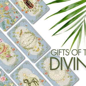 Puede incluir: Un juego de cartas de tarot con fondo azul e ilustraciones intrincadas. Las cartas presentan una variedad de símbolos e imágenes, incluyendo flores, estrellas y cuerpos celestes. Las cartas están dispuestas en forma de abanico, con el texto "Gifts of the Divine" visible en la parte inferior de la imagen.