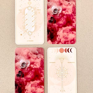 Peut inclure: Deux cartes de tarot avec des fonds rose et blanc. La carte Huit de B&acirc;tons montre une baguette dor&eacute;e sur un fond blanc avec le texte "Huit de B&acirc;tons". La carte Page d'&Eacute;p&eacute;es montre une &eacute;p&eacute;e dor&eacute;e sur un fond blanc avec le texte "Page d'&Eacute;p&eacute;es".