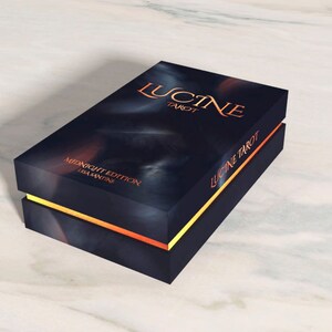 K&ouml;nnte beinhalten: Eine schwarze Box mit goldenen und orangenen Verzierungen. Auf der Box steht "Lucine Tarot" und "Midnight Edition".