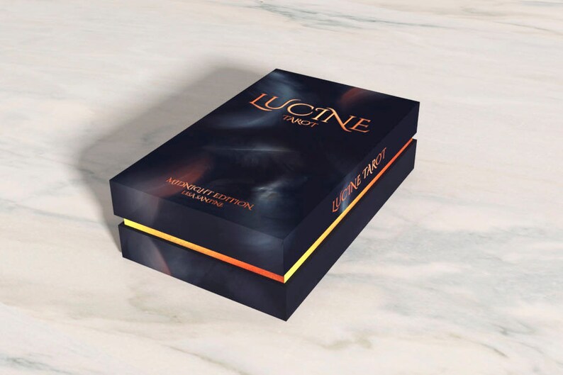 K&ouml;nnte beinhalten: Eine schwarze Box mit goldenen und orangenen Verzierungen. Auf der Box steht "Lucine Tarot" und "Midnight Edition".