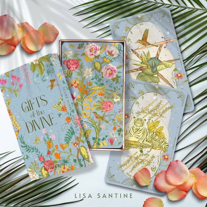 May include: A deck of oracle cards called "Gifts of the Divine" by Lisa Santine. The box features a floral design with a blue background. The cards have a light blue background with gold accents and illustrations of animals and plants.