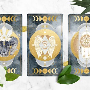 K&ouml;nnte beinhalten: Drei Tarotkarten mit goldenen und wei&szlig;en Designs auf blauem Hintergrund. Die Karten sind mit "IV Kaiser", "XX Gericht" und "XVII Der Stern" beschriftet.