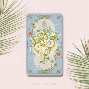 May include: A blue and gold tarot card with the number 24 and the words "Three of Cups" on it. The card features an illustration of three golden cups overflowing with water, surrounded by flowers and vines.