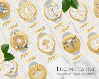May include: A set of tarot cards with gold and white illustrations on a white background. The cards feature a variety of symbols and imagery, including moons, stars, and animals. The cards are arranged in a grid pattern, and the text "LUCINE TAROT TWILIGHT EDITION BY LISA SANTINE" is visible at the bottom of the image.