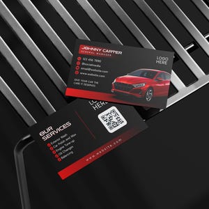 May include: Two rectangular business cards with a black and red colour scheme. One card displays the name Johnny Carter, a red car graphic, and contact details. The other card lists services including exterior wash and oil changes with a QR code.