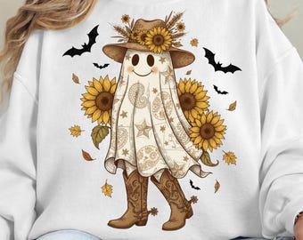 May include: White sweatshirt featuring a cartoon ghost wearing a cowboy hat adorned with sunflowers and wheat. The ghost is draped in a paisley patterned sheet, cowboy boots, and surrounded by sunflowers, bats, and autumn leaves. The text "PNG File - Digital Download Only (No Physical Item)" is at the bottom.