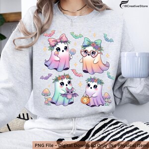 Peut inclure: Un sweat-shirt gris clair avec une illustration color&eacute;e de quatre adorables fant&ocirc;mes orn&eacute;s de couronnes de fleurs, de n&oelig;uds et d'accessoires. Le motif comprend &eacute;galement des chauves-souris et des champignons. Le texte "PNG File - Digital Download Only (No Physical Item)" est en bas.