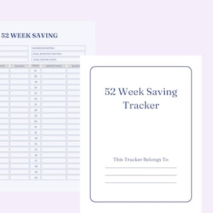 May include: A white 52 Week Saving Tracker notebook with a blue border. The cover has the title "52 Week Saving Tracker" in a serif font. The notebook includes sections for tracking savings goals and dates.