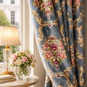 May include: Blue velvet curtains with a floral design in pink, red, and gold. A small table with a lamp and a vase of flowers is next to the curtains. The curtains have an ornate, classic design, suitable for a living room.
