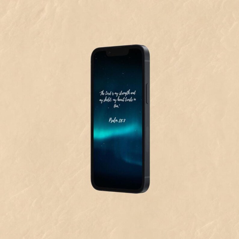 May include: A black smartphone displaying a dark blue and teal background with white text. The text reads "The Lord is my strength and my shield: my heart trusts in Him." and "Psalm 28:7."