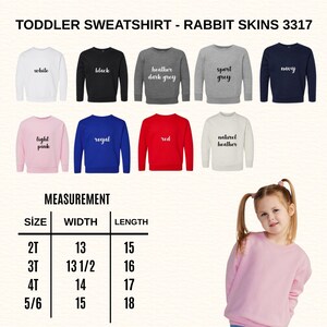 May include: A selection of toddler sweatshirts in various colors, including white, black, heather gray, sport gray, navy, light pink, royal blue, and red. The image also includes a size chart with measurements in inches for width and length.