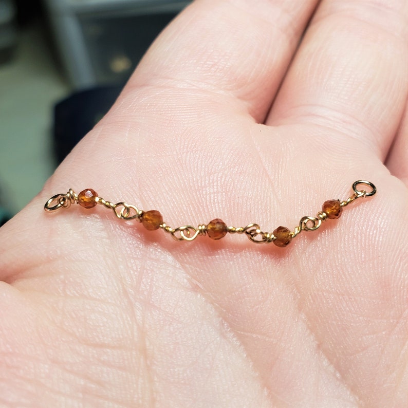 Handmade over the nose bridge double piercing chain with small carnelian gemstones. Beads are 1.5 mm and clear dark honey brown with sparkling facets. Ends are 3 mm jump rings. Metal choices: Silver or Gold Plated, Sterling Silver, and 14K Gold.