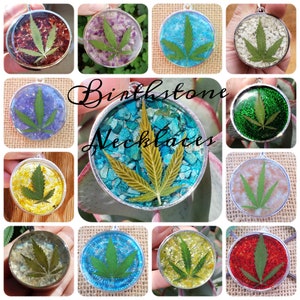Puede incluir: Un collage de 12 colgantes redondos con una hoja de marihuana verde encapsulada en resina de varios colores. La resina está hecha con piedras preciosas trituradas, purpurina y otros materiales. El texto "Birthstone Necklaces" está superpuesto a la imagen.