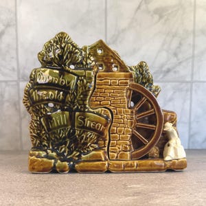 May include: A handmade wooden serving tray with a natural finish. The tray has a rectangular shape with rounded corners and raised edges. It features two handles for easy carrying. The tray measures approximately 45 cm long and 30 cm wide.