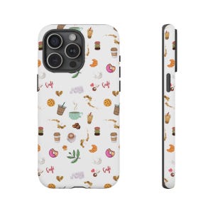 May include: White phone case featuring a repeating pattern of cafe-related illustrations. The design includes coffee cups, croissants, donuts, macarons, and the word "Cafe". The case has a black camera module and a black border.