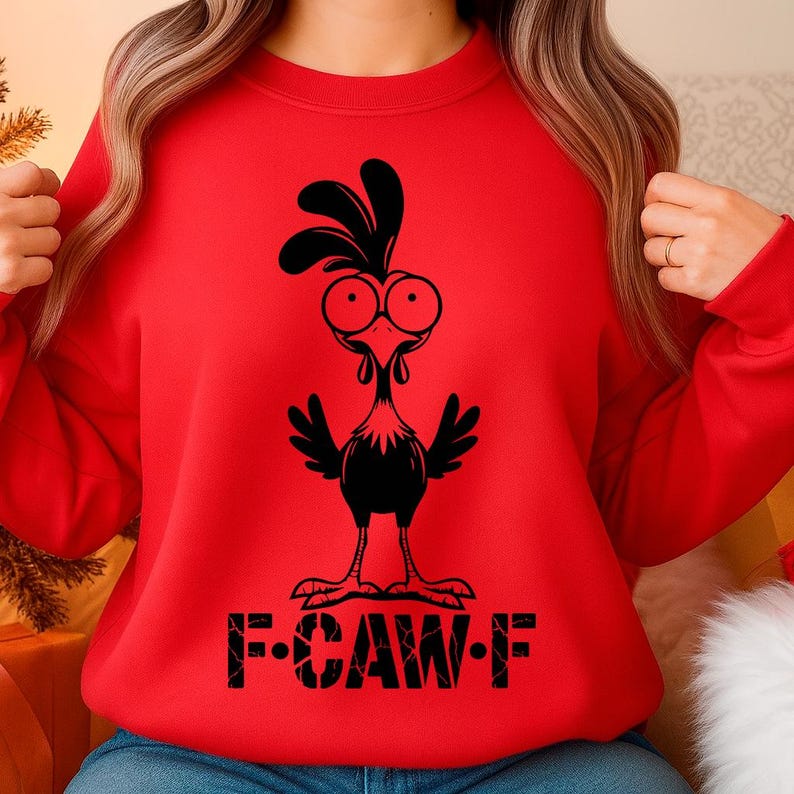 May include: A red sweatshirt featuring a black cartoon rooster design. The rooster has large eyes and a comb, with the text "F-CAW-F" printed below. The sweatshirt is a casual, comfortable style.