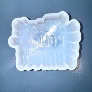 Puede incluir: Un molde de silicona transparente y flexible con el texto "OH SH!T I'M THIRTY!" en una fuente burbujeante. El molde tiene una forma redondeada e irregular con una superficie texturizada, sobre un fondo gris oscuro.