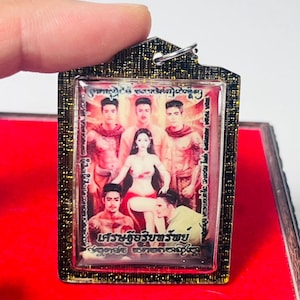 Puede incluir: Colgante rectangular con marco dorado e imagen detallada. La imagen presenta una figura femenina central rodeada de cinco figuras masculinas. El marco tiene un patrón oscuro y texturizado. Texto tailandés visible en la parte inferior de la imagen.