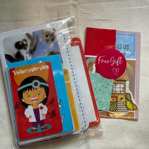 May include: A stack of rectangular cards in clear plastic packaging. The top card features a cartoon veterinarian in a white coat with the text "Veterinarian". A second package includes a pink circular sticker with the text "Free Gift" and a heart.