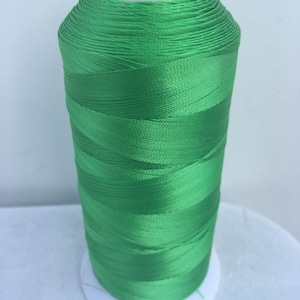 May include: A spool of bright green embroidery thread.