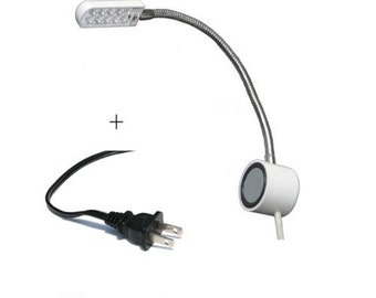 May include: White LED desk lamp with a flexible gooseneck arm and a magnetic base. The lamp is plugged into a standard US electrical outlet.