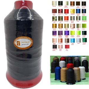 May include: A large spool of black sewing thread wrapped in clear plastic, featuring a circular label with the text Item4ever sewing & crafts. Beside it is a color chart displaying various thread shades and a collection of assorted thread spools.