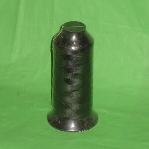 May include: A spool of black thread wrapped in clear plastic.