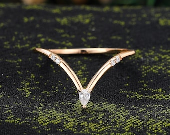 Anillo de moissanita talla pera con diseño de horquilla y chevron, alianza de boda curva de oro amarillo.