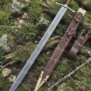 May include: A double-edged sword with a patterned Damascus steel blade, a cross-shaped metal guard, and a dark wood handle. It is accompanied by a matching dark wood scabbard featuring intricate carvings, brass accents, and a brown leather strap.