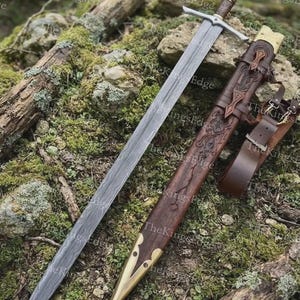 May include: A longsword with a patterned Damascus steel blade, a silver-toned crossguard, and a dark wooden grip. The matching wooden scabbard features intricate carvings, brass fittings at the tip and throat, and an attached brown leather belt.