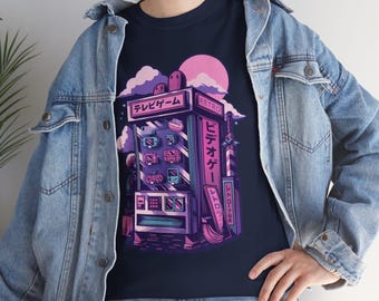 May include: Navy blue t-shirt featuring a retro arcade game machine design in shades of purple, pink, and white. The design includes Japanese text and a stylized sunset. A classic video game theme.