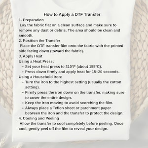 May include: White background with instructions on how to apply a DTF transfer. The text includes steps for preparation, positioning the transfer, applying heat with a heat press or iron, and cooling and peeling.