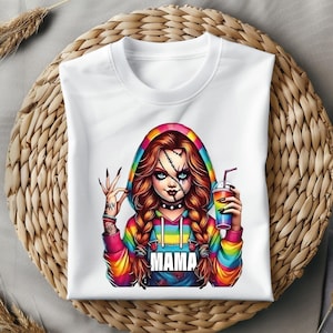 May include: White hooded sweatshirt featuring a colorful graphic of a doll-like character with stitched scars, holding a rainbow drink. The character has red hair in braids and the word "MAMA" is printed on the front.
